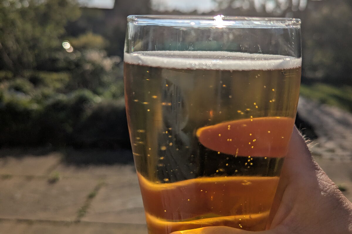 Ein mit Bier (Oberdorfer Helles) gefülltes Glas mit Abendsonne im Hintergrund